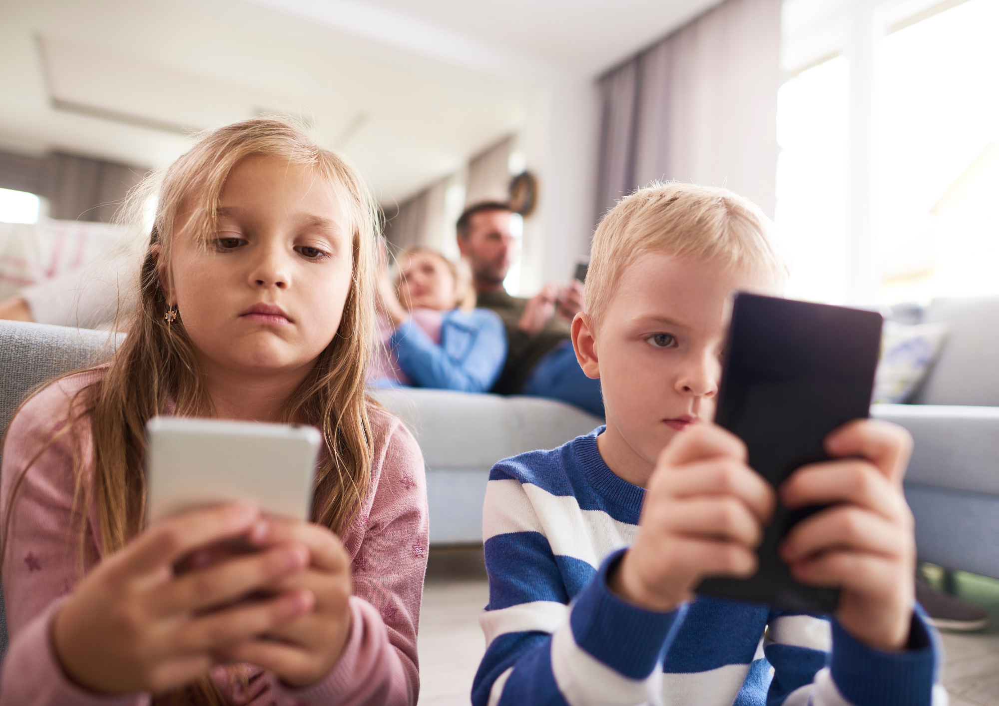 Twee kinderen die bezig zijn op hun telefoon