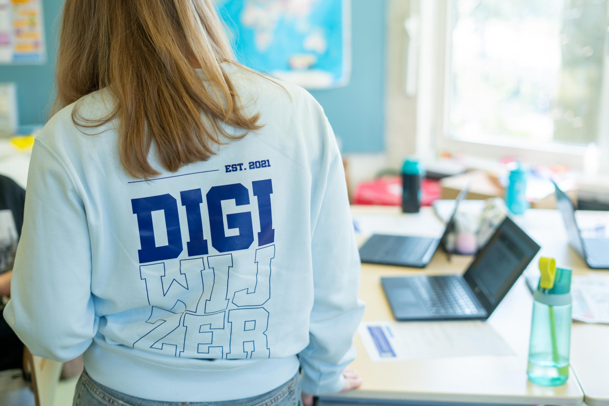 Digicoach van Digiwijzer Nederland in een klaslokaal tijdens een les over digitale vaardigheden.