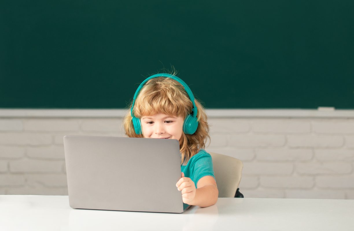 Kind in klaslokaal leert over nepnieuws via educatieve game op laptop