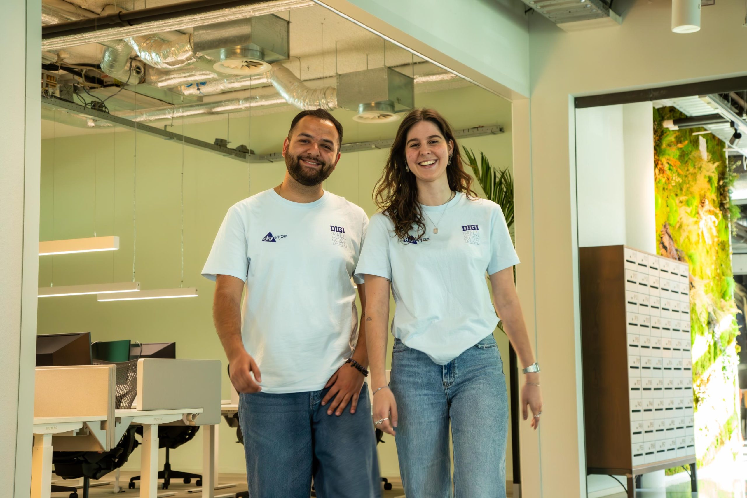 Twee collega’s van Digiwijzer in kantoor, klaar om scholen te ondersteunen tijdens de Week van de Mediawijsheid