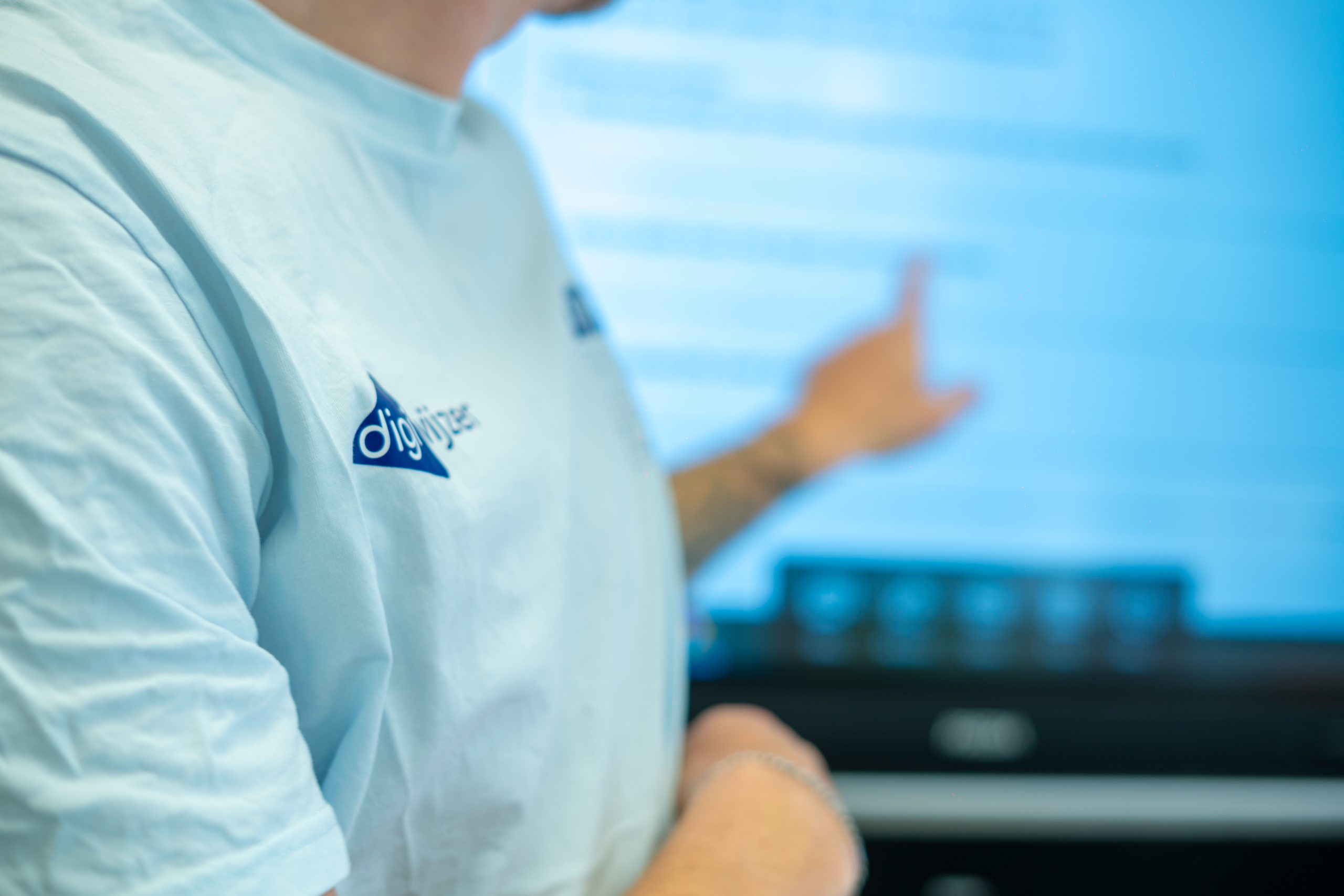 digicoach wijst tijdens een interactieve presentatie op het digibord.