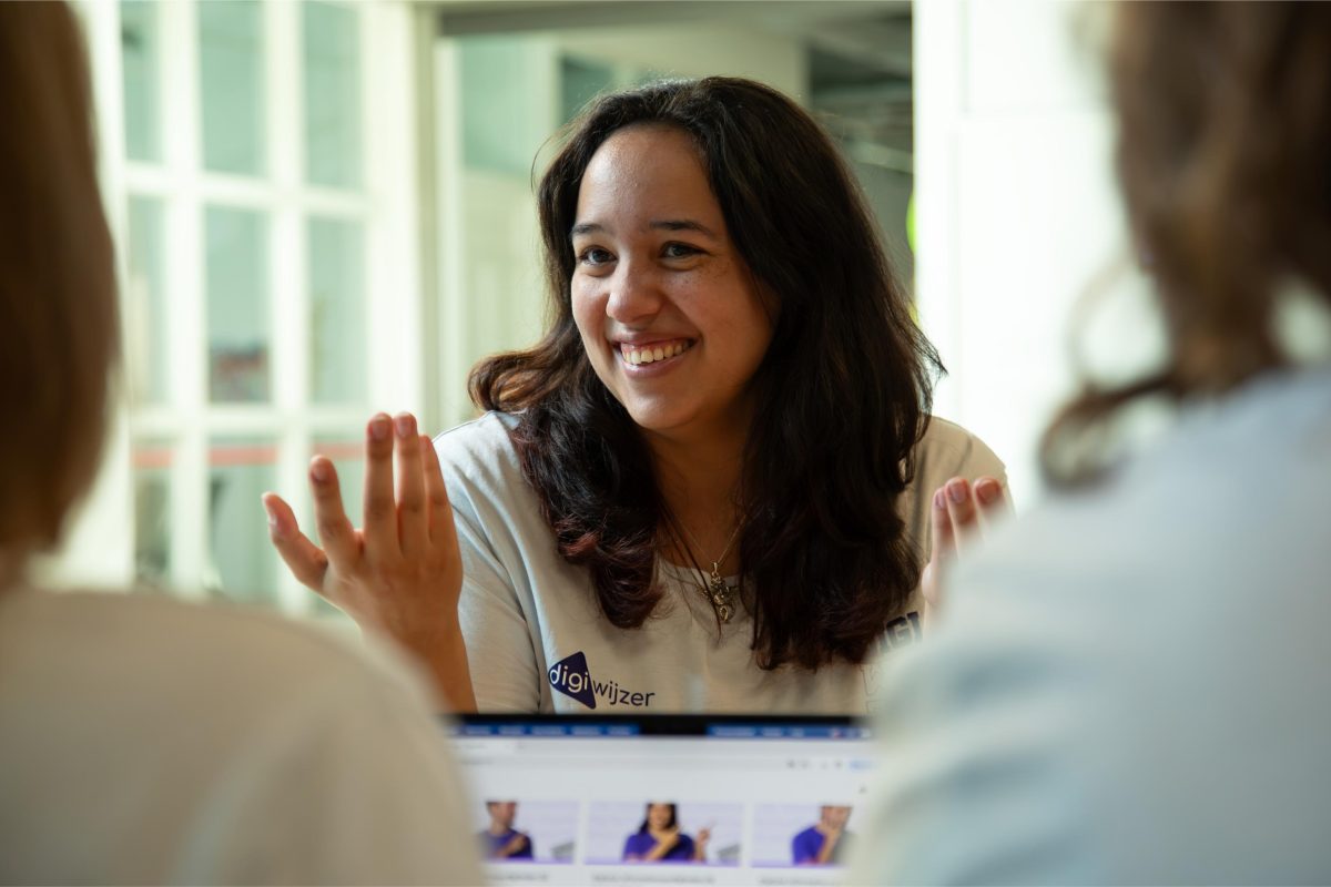 Een Digiwijzer-trainer in gesprek met onderwijsprofessionals over de implementatie van digitale geletterdheid.