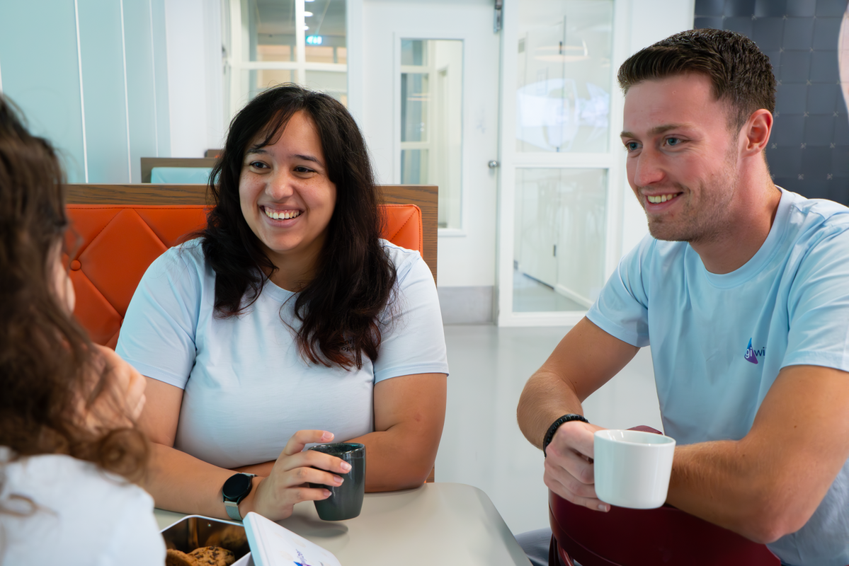 Twee teamleden van Digiwijzer in gesprek met een collega tijdens een informele koffiebreak.
