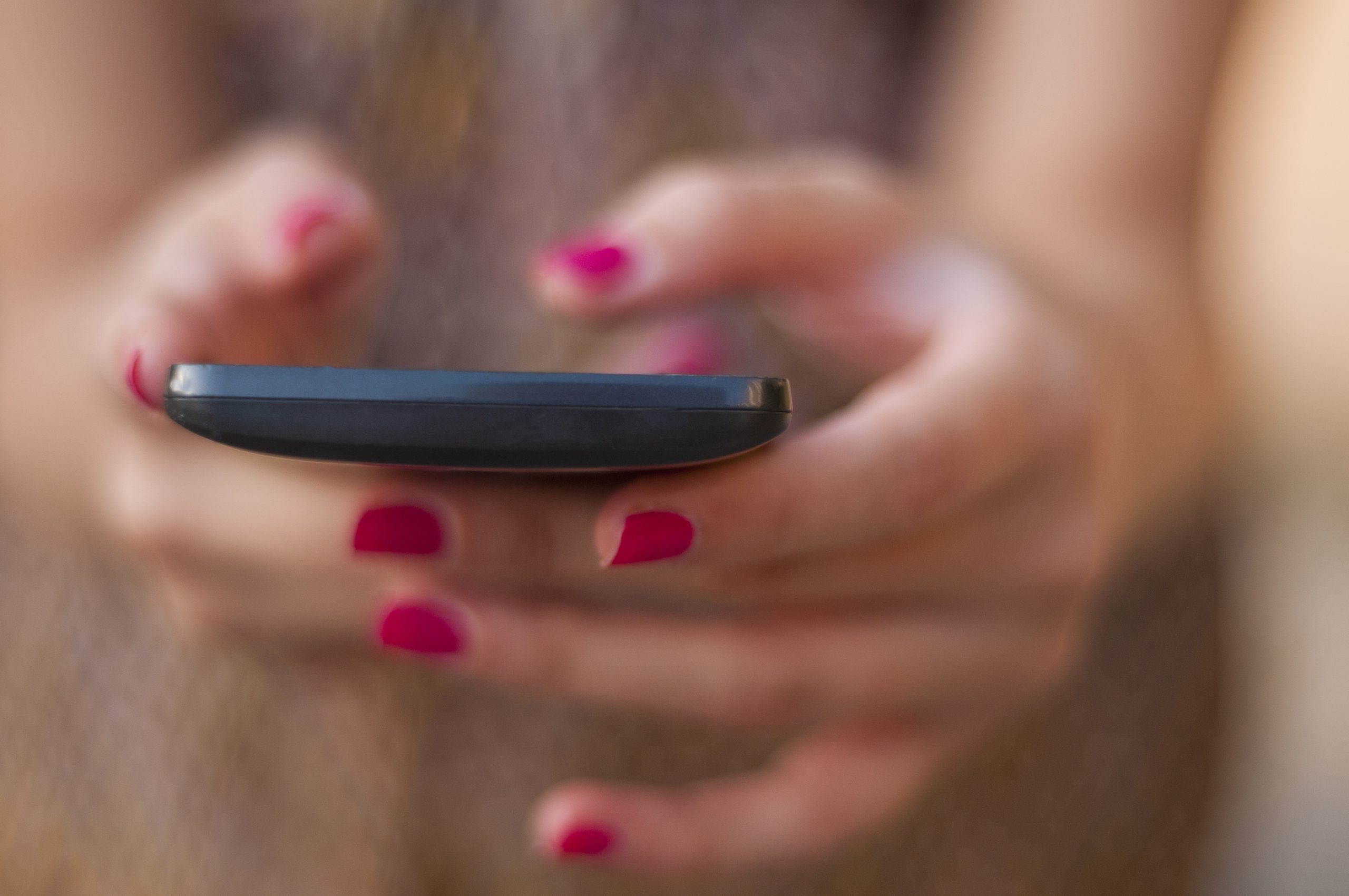 Jongere gebruikt smartphone voor chatten op Snapchat of Instagram.