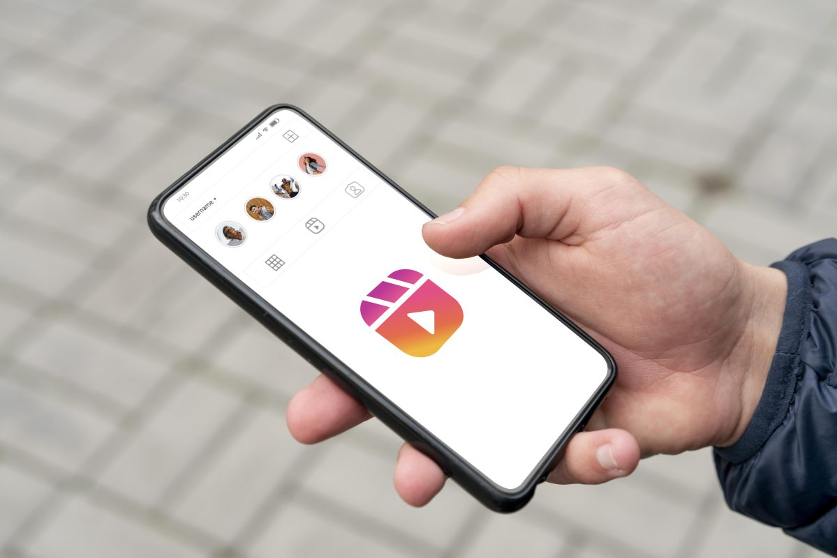 Smartphone met Instagram Reels-logo, symbool voor AI-beelden op Instagram en de impact van misleidende content op jongeren.