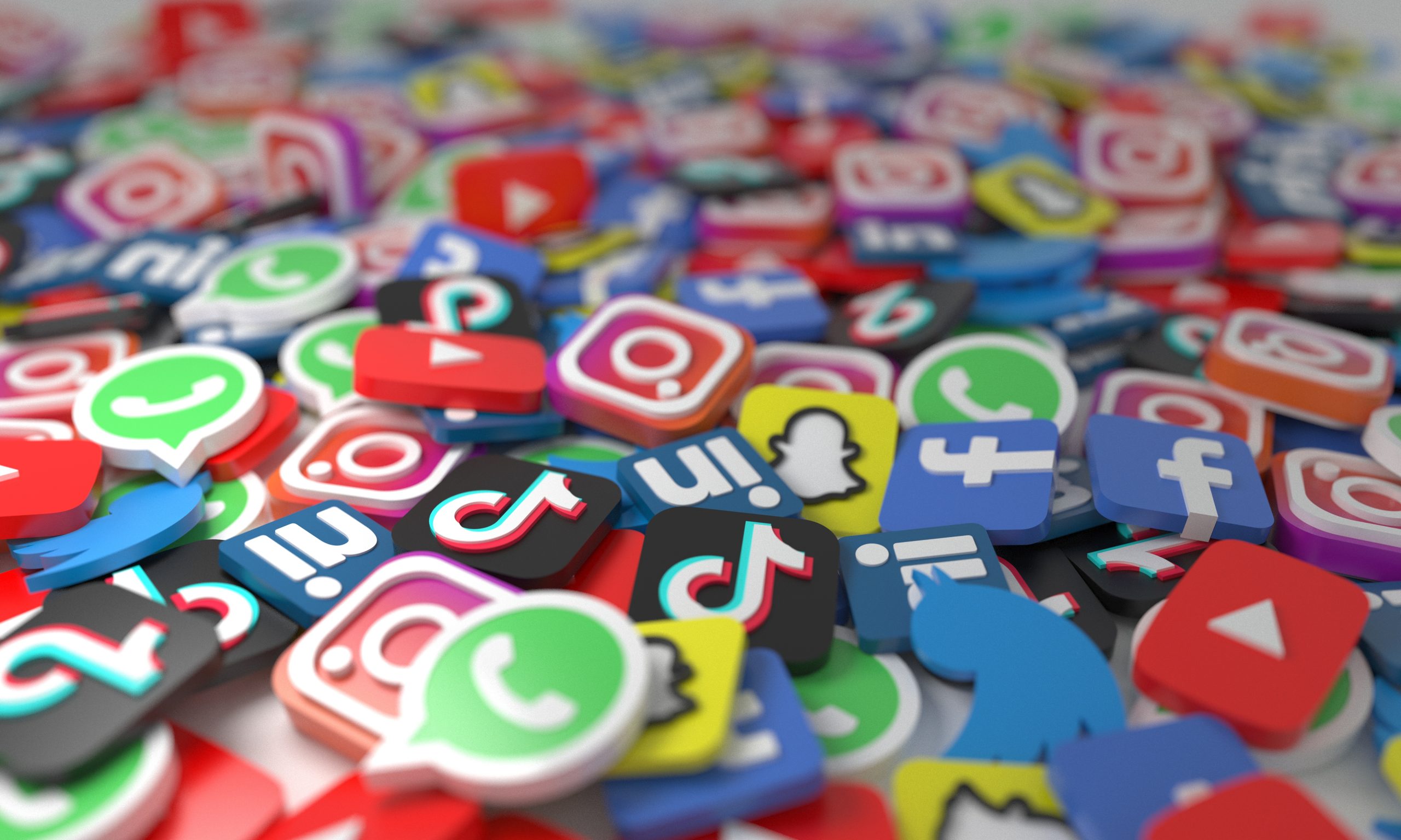 Iconen van populaire social media apps zoals WhatsApp, TikTok, Instagram en YouTube die verspreid liggen.