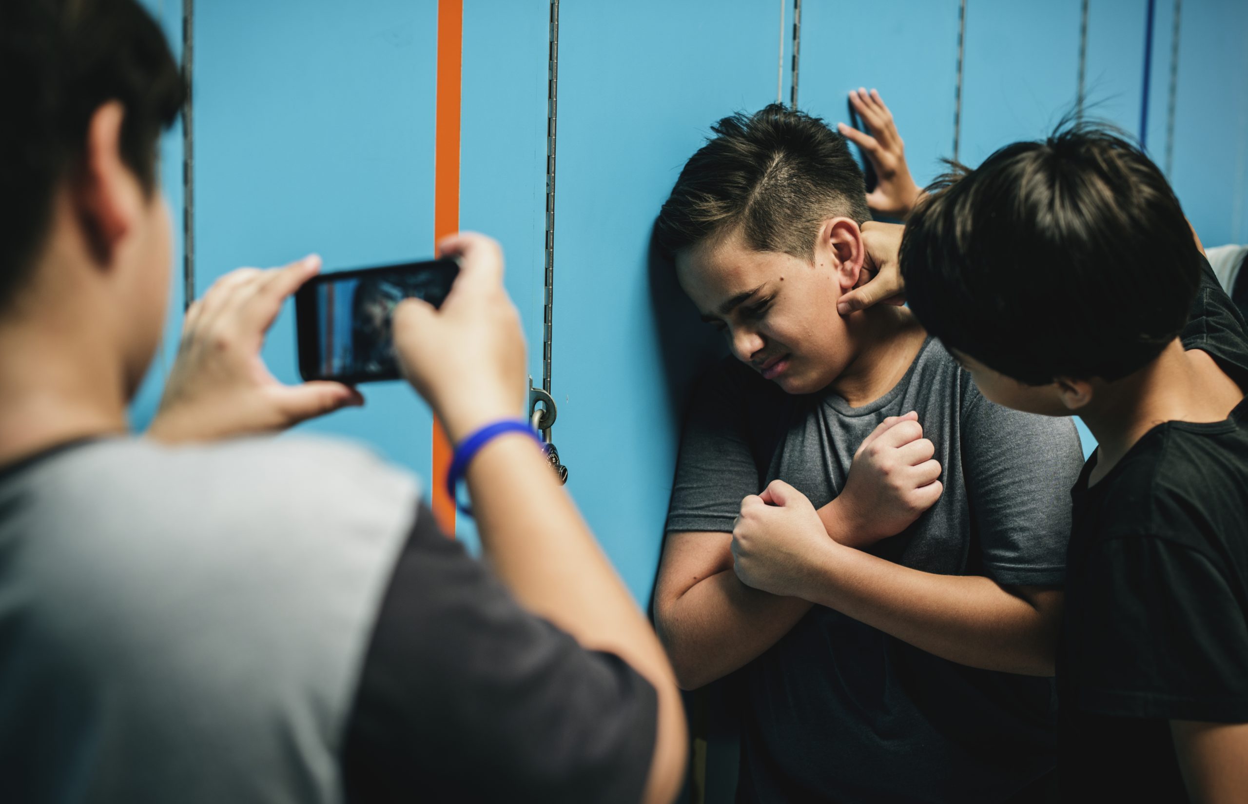 Leerling wordt op school gepest terwijl een andere leerling het filmt met een smartphone