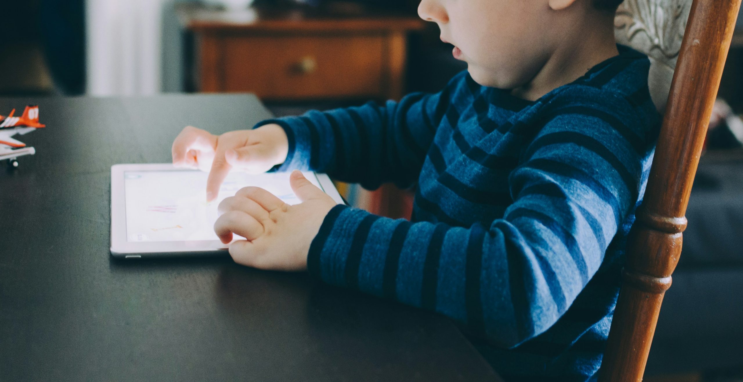 jong kind gebruikt tablet aan tafel meerdere digitale apparaten jonge kinderen