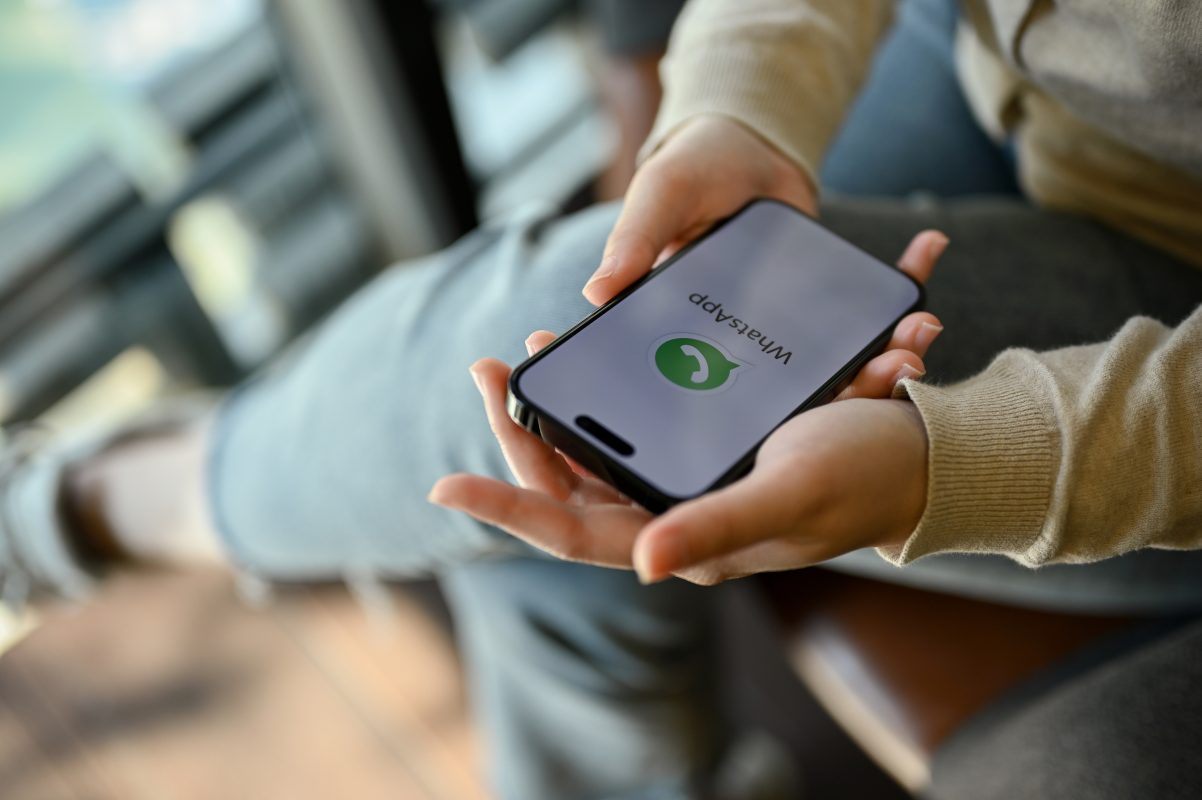Persoon houdt een smartphone met WhatsApp in de hand. De nieuwe WhatsApp gebruikersnaam maakt chatten mogelijk zonder telefoonnummer te delen.