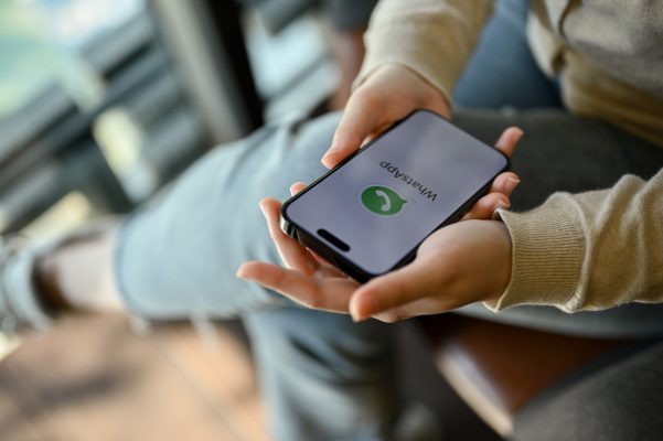 Persoon houdt een smartphone met WhatsApp in de hand. De nieuwe WhatsApp gebruikersnaam maakt chatten mogelijk zonder telefoonnummer te delen.
