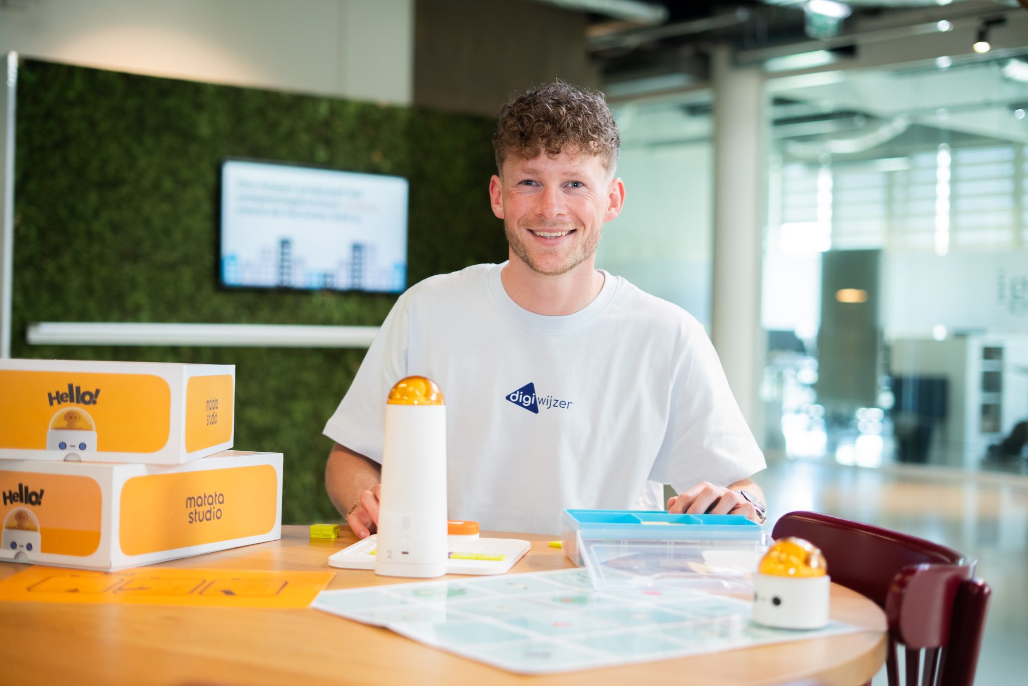 Digiwijzer-medewerker werkt met educatieve programmeerrobots en lesmateriaal tijdens een opleiding digitale geletterdheid.