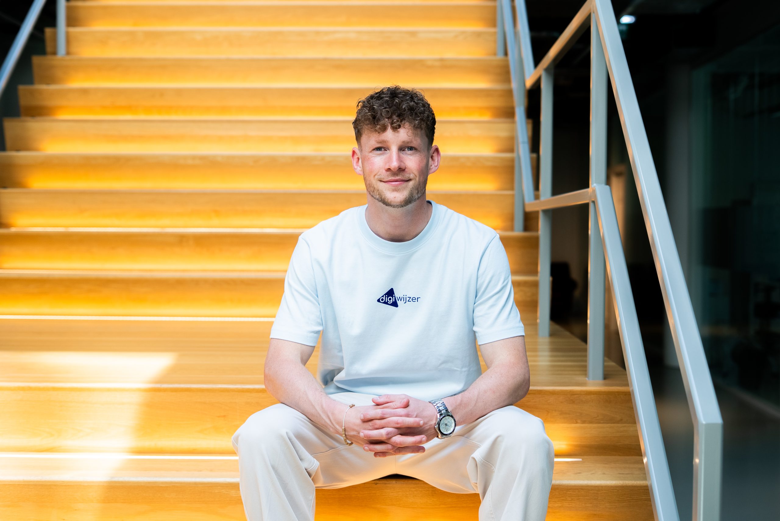 Portret van een Digiwijzer-adviseur op een trap, passend bij een maatwerktraject voor de implementatie van digitale geletterdheid.