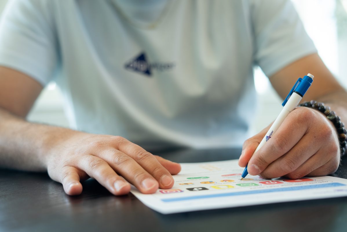Een Digiwijzer-medewerker maakt aantekeningen op een werkblad tijdens een brainstormsessie over digitale geletterdheid.