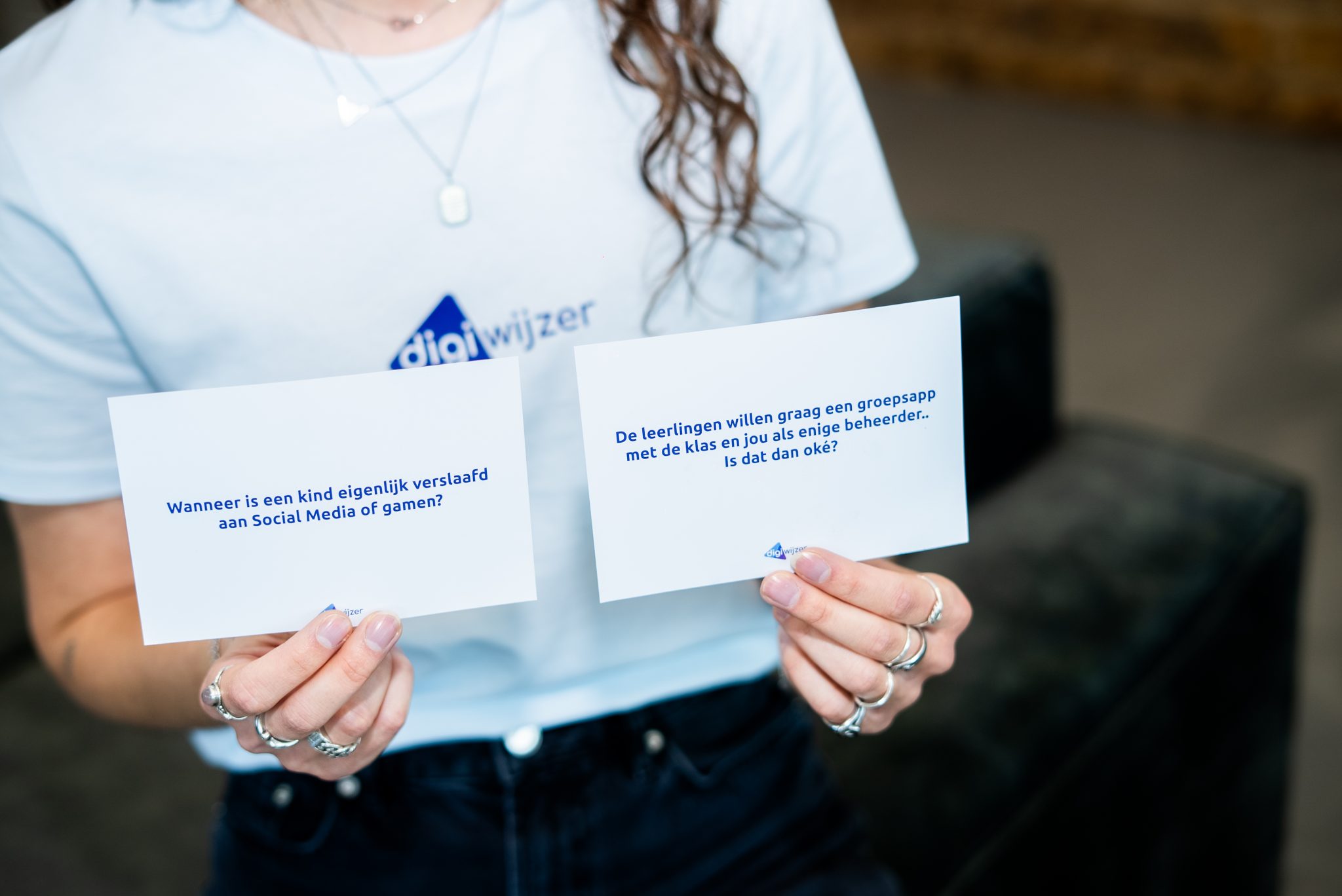 Digiwijzer-specialist houdt gesprekskaarten vast met vragen over sociale media, gamen en online gedrag.