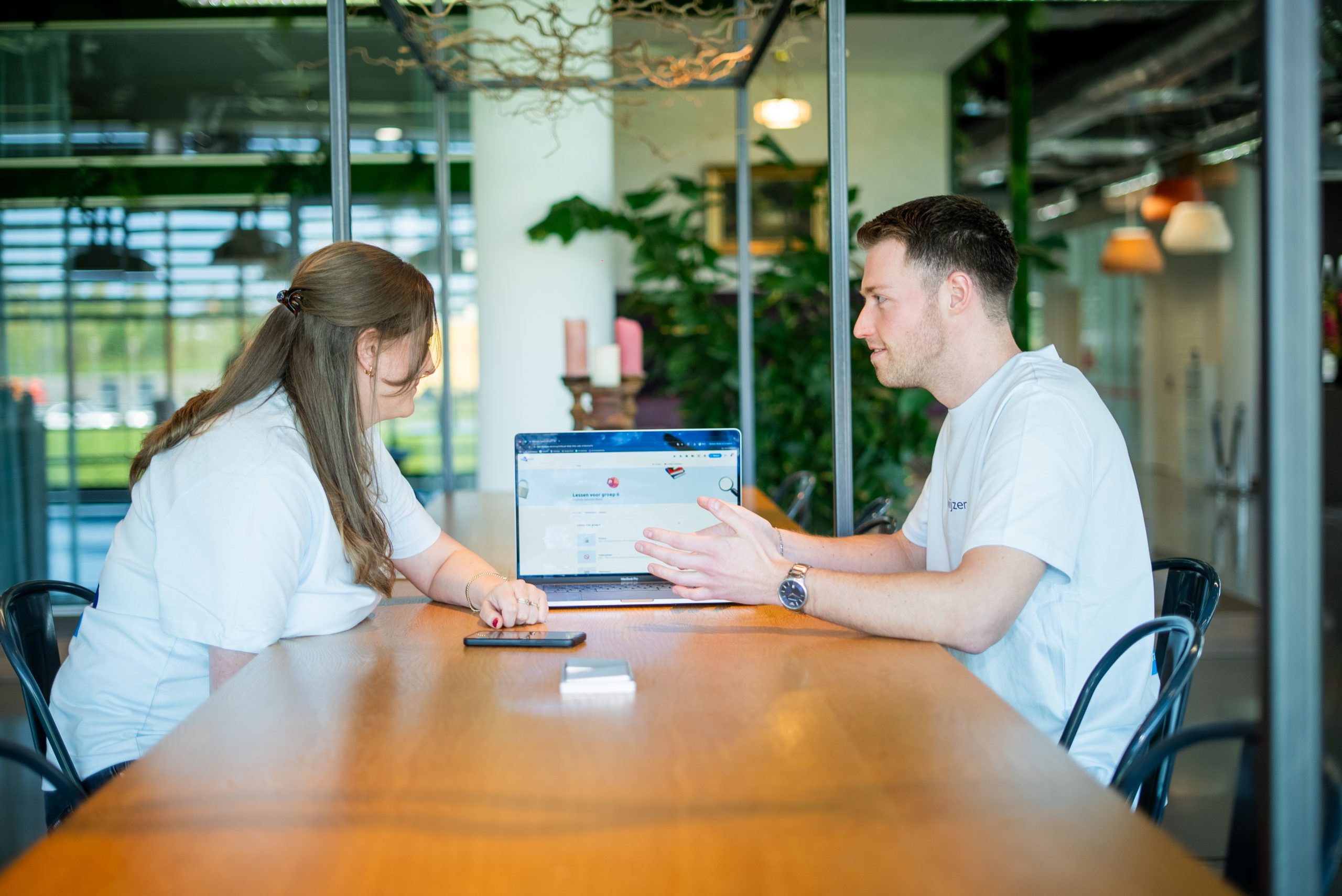 Twee collega's bespreken lessen digitale geletterdheid en burgerschap aan de hand van een online leeromgeving.