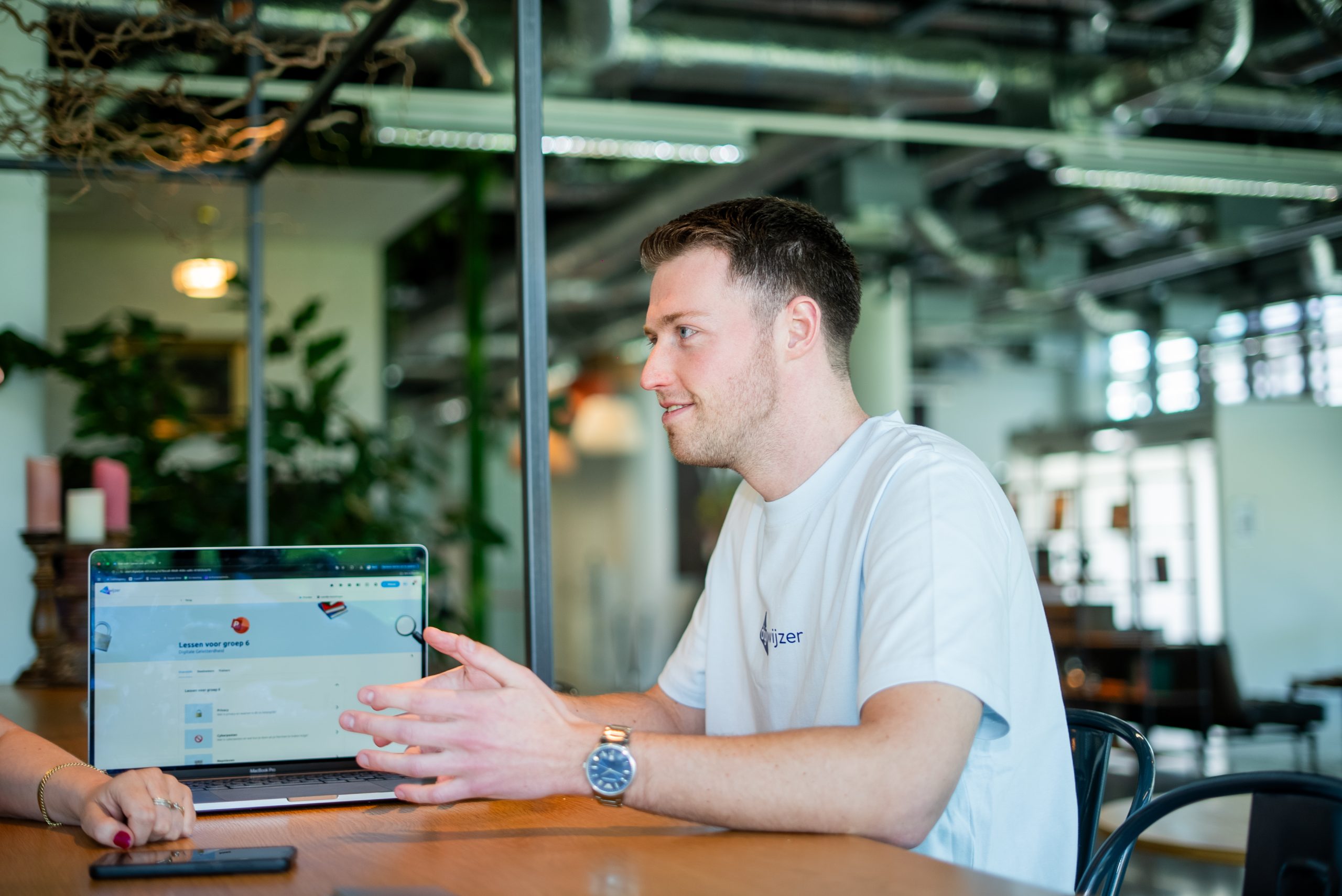 Een Digiwijzer-adviseur bespreekt de online leeromgeving en lesmaterialen met een collega tijdens een adviesgesprek.