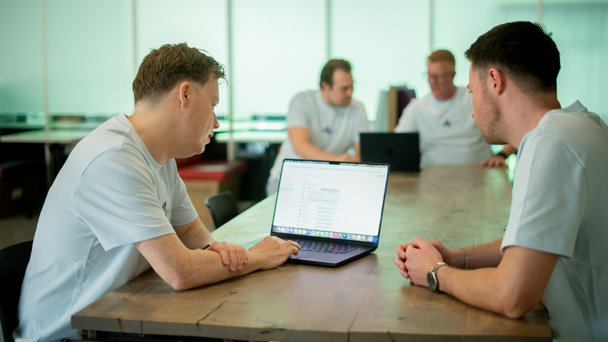 Digiwijzer-medewerkers bespreken de methode Digitale Geletterdheid en het digitale lesmateriaal op een laptop.