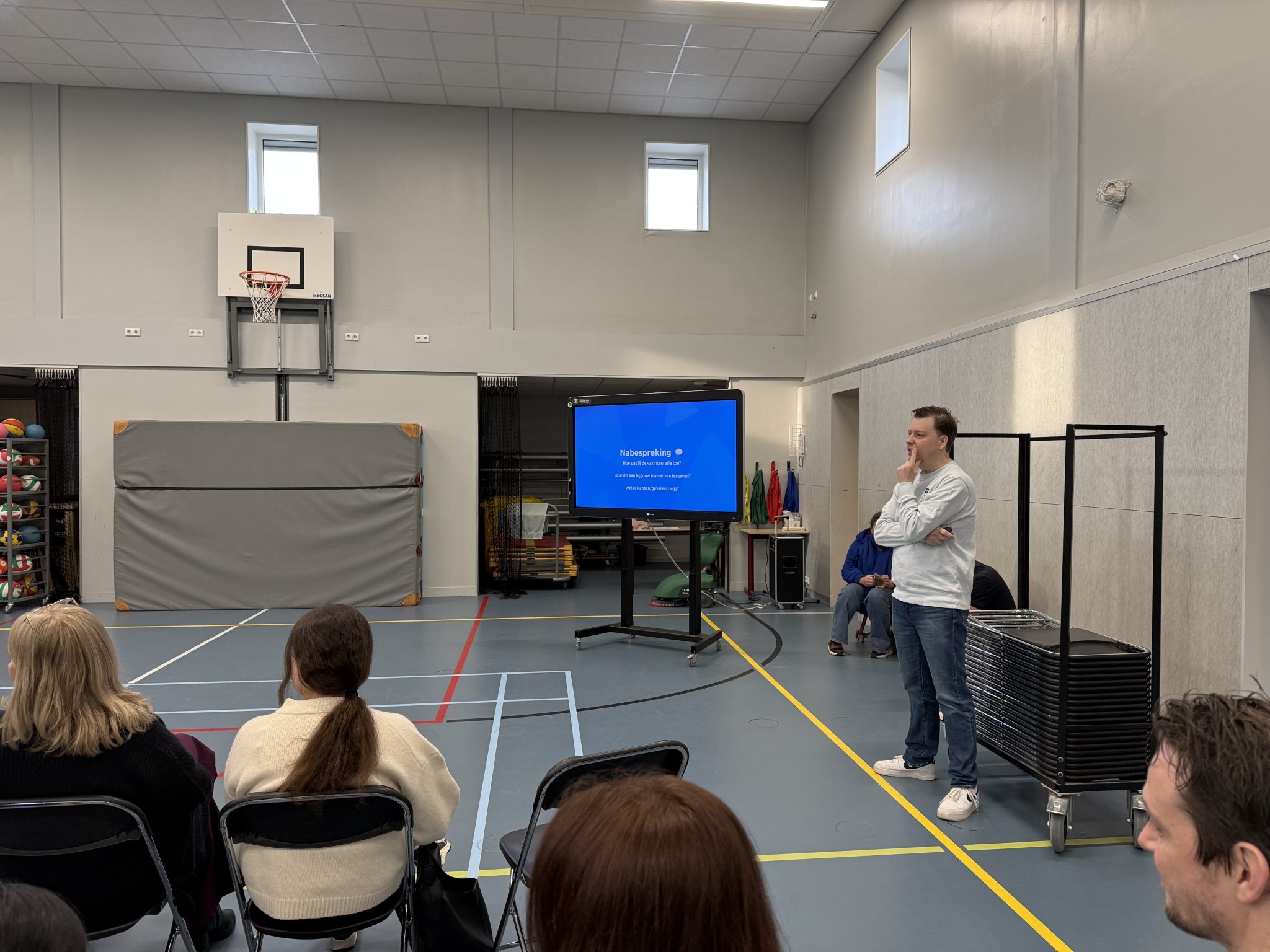 Medewerker van Digiwijzer verzorgt een interactieve presentatie voor een groep leerkrachten tijdens een teamtraining over digitale geletterdheid.