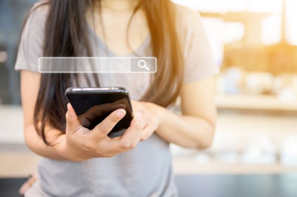 Jongere zoekt informatie op een smartphone, als symbool voor het veranderende zoekgedrag van jongeren.