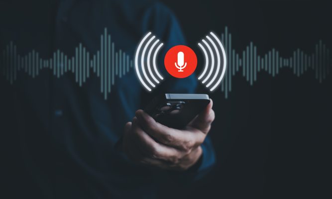 Persoon met smartphone en geluidsgolven als illustratie van voice cloning met AI.