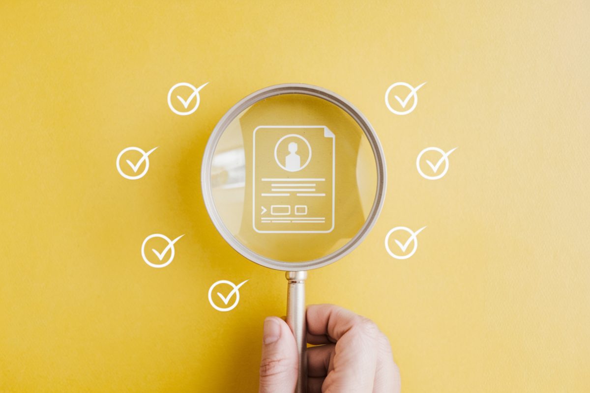 Vergrootglas boven een digitaal identiteitsbewijs met vinkjes als symbool voor online leeftijdscontrole.