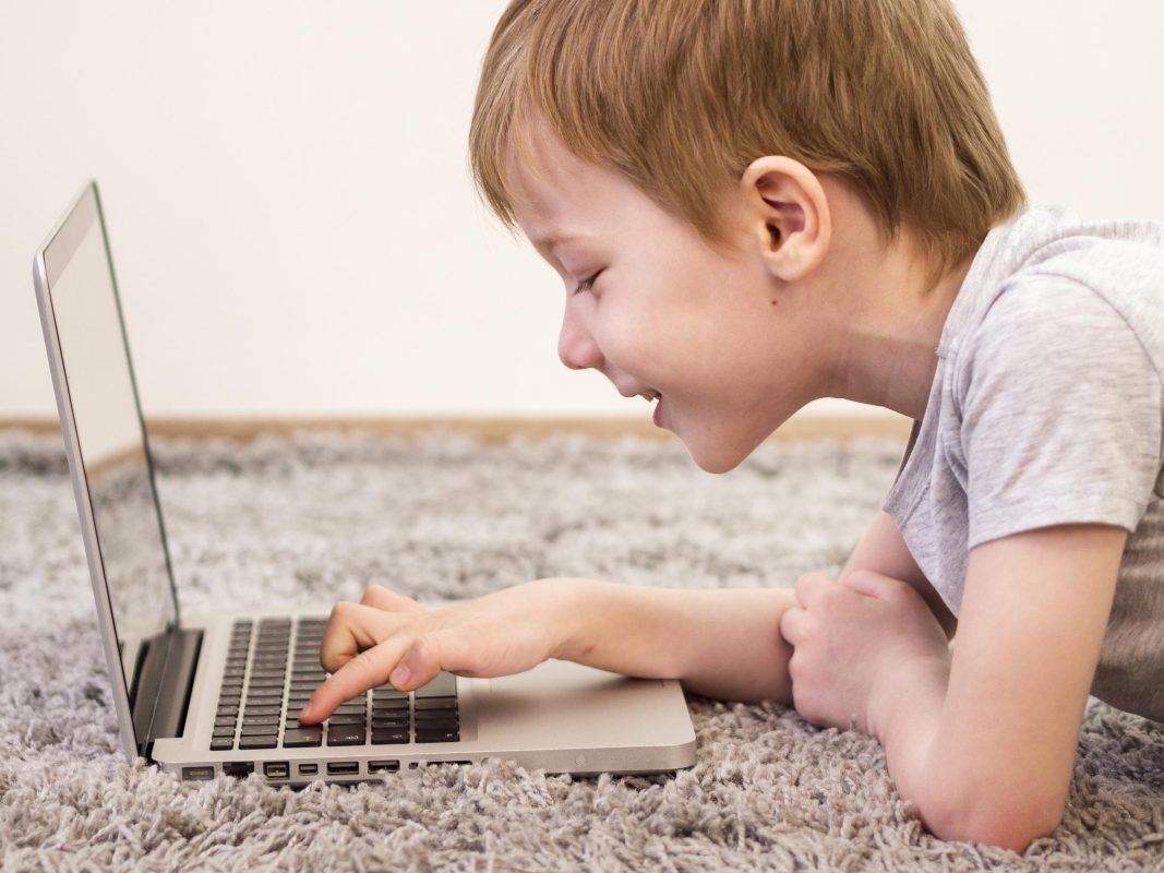 Jonge jongen gebruikt een laptop. Een beeld bij anoniem internetten, online tracking en de digitale privacy van kinderen.